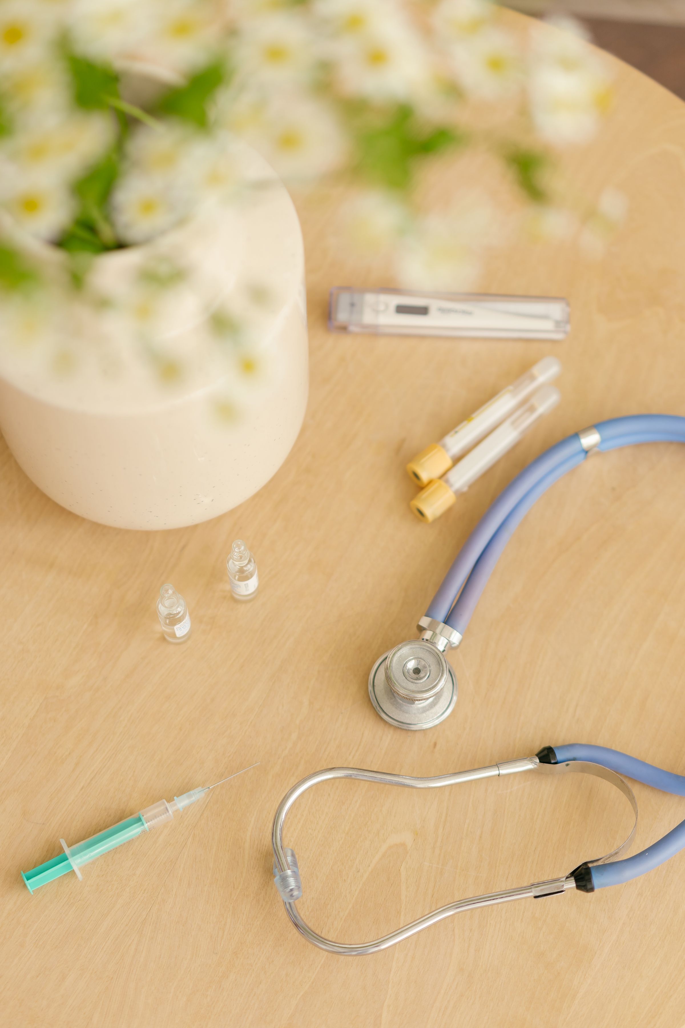 A stethoscope and medical supplies on a wooden table.