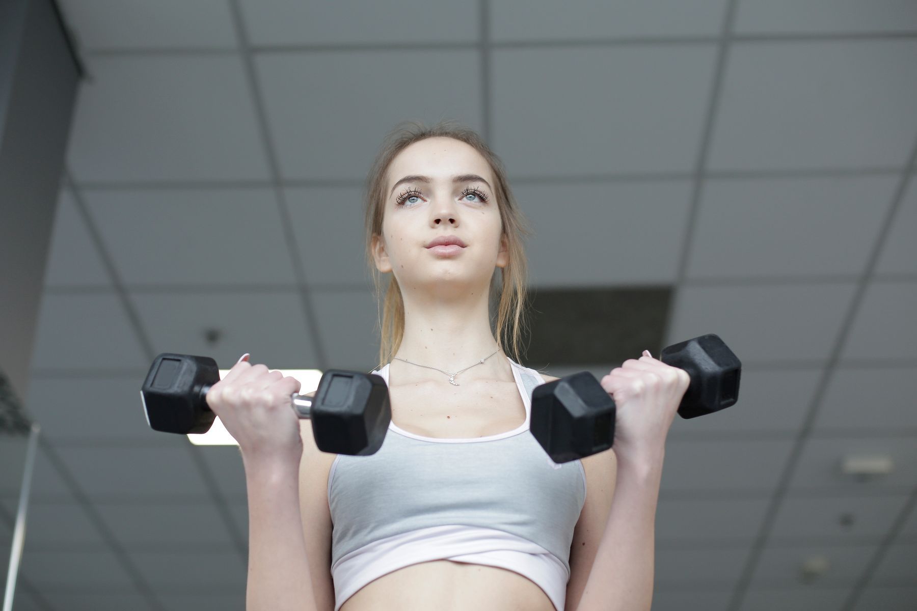 A woman exercising with two dumbbells.