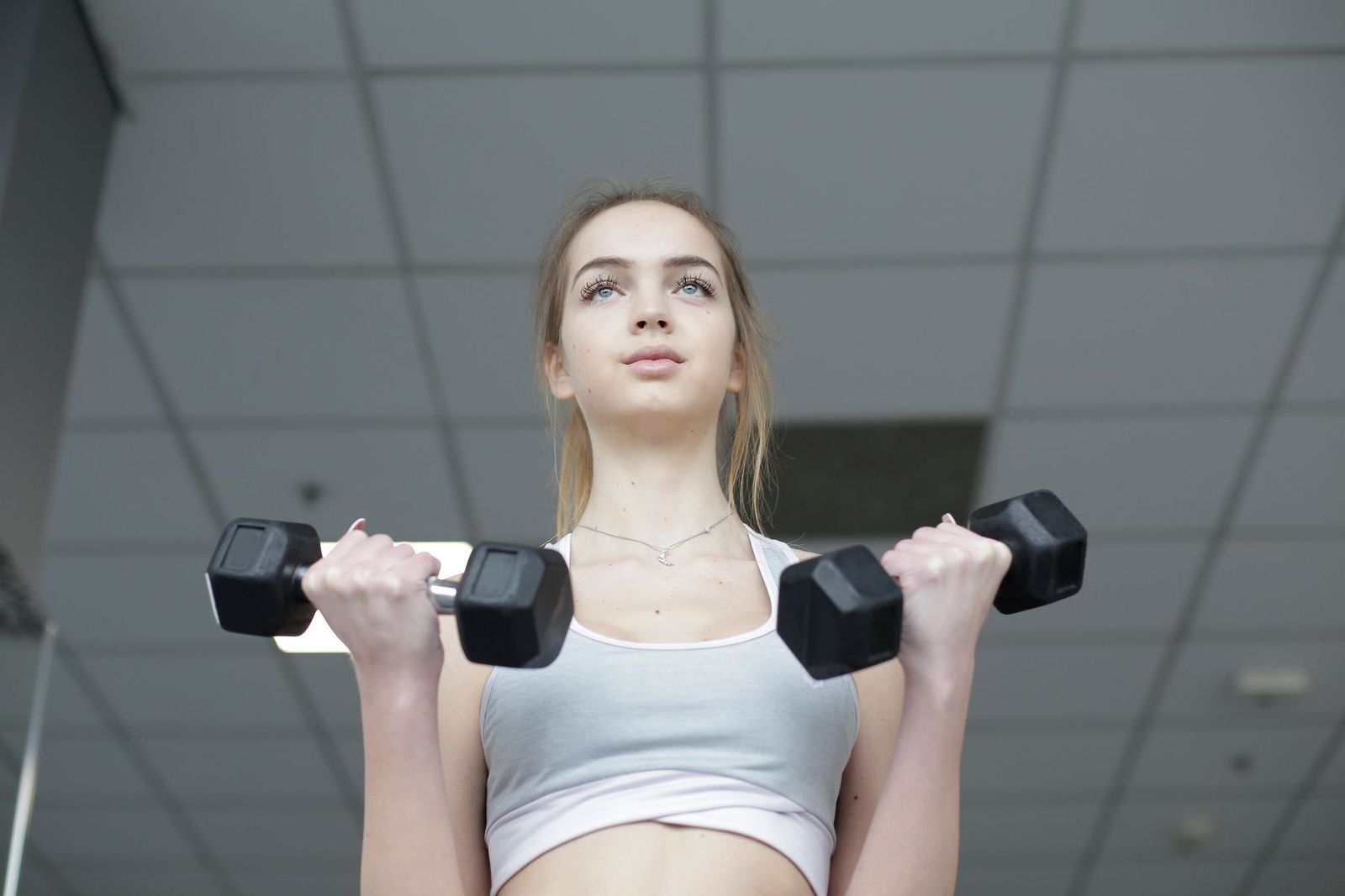 A woman exercising with two dumbbells.