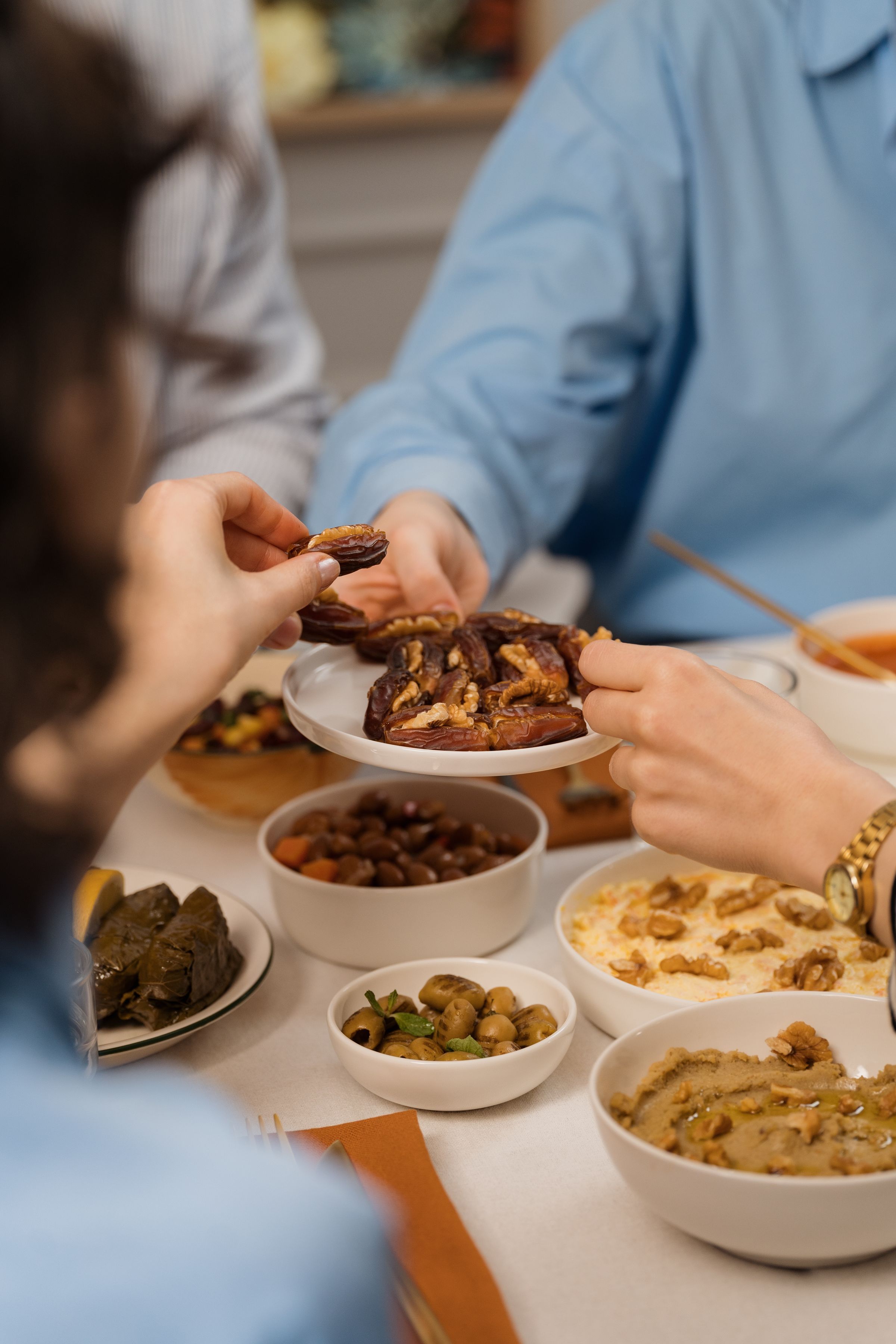 Hands serving food around a shared table.