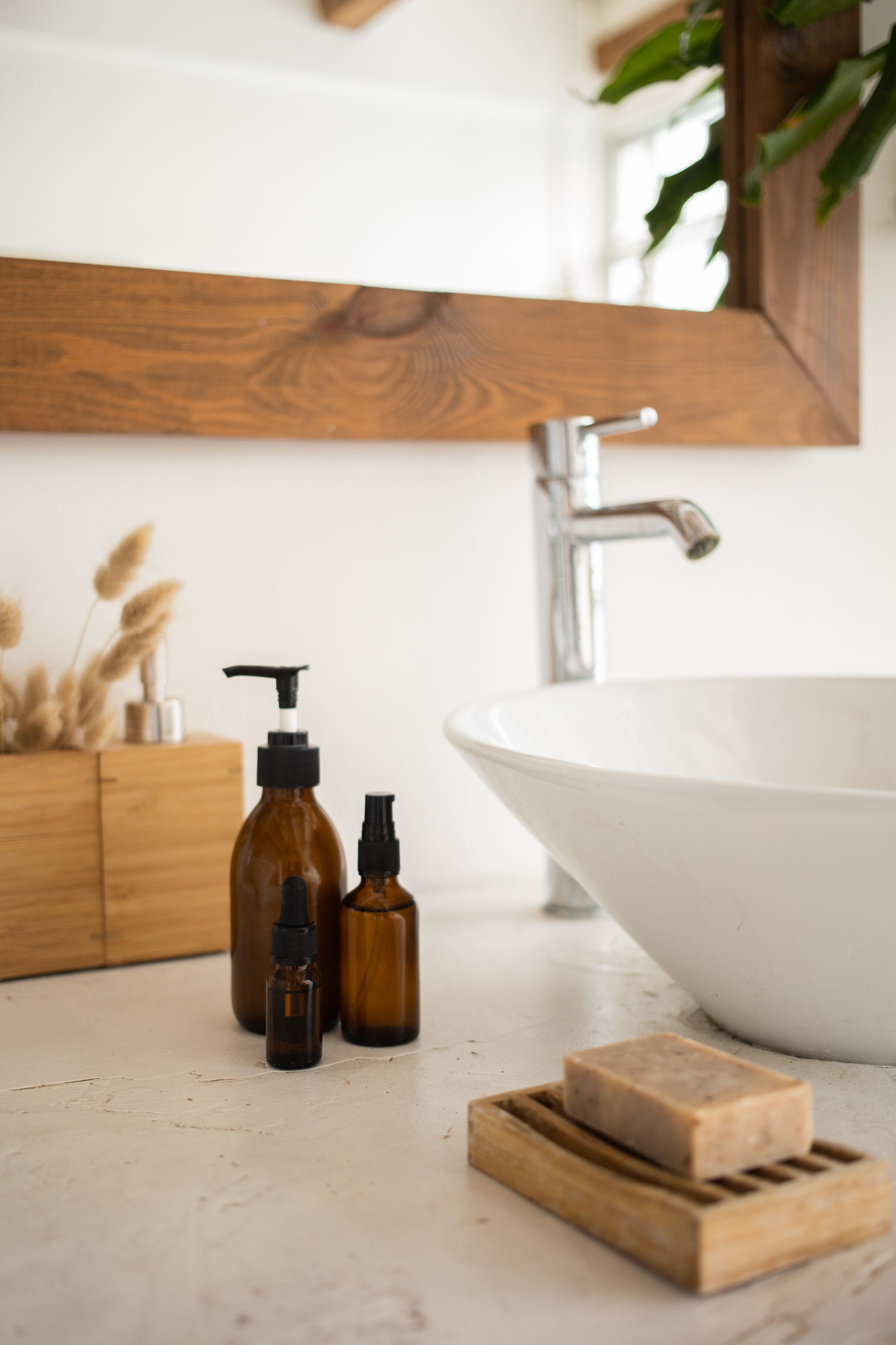 Brown bottles and a bar of soap beside a bathroom sink.