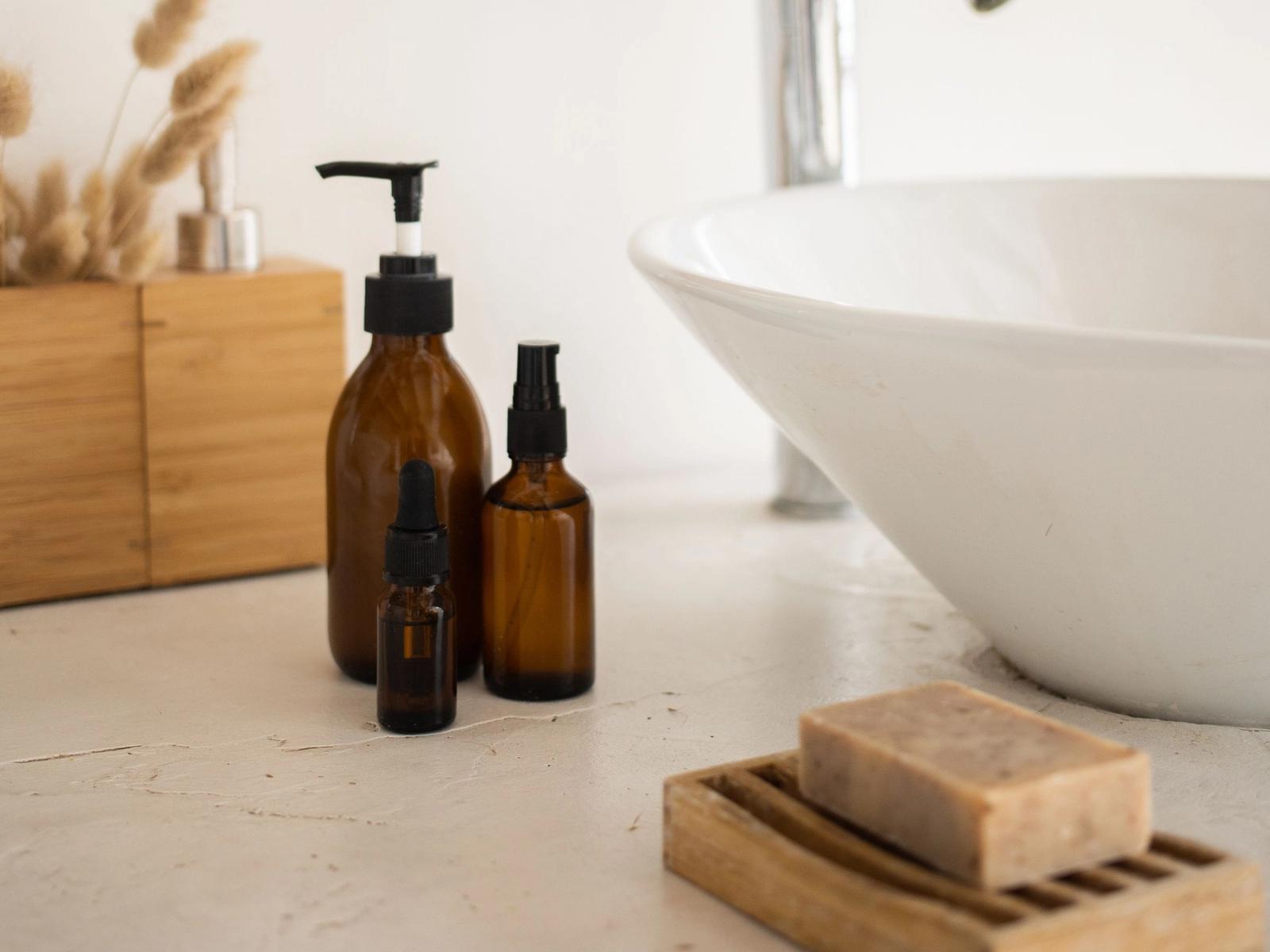 Brown bottles and a bar of soap beside a bathroom sink.