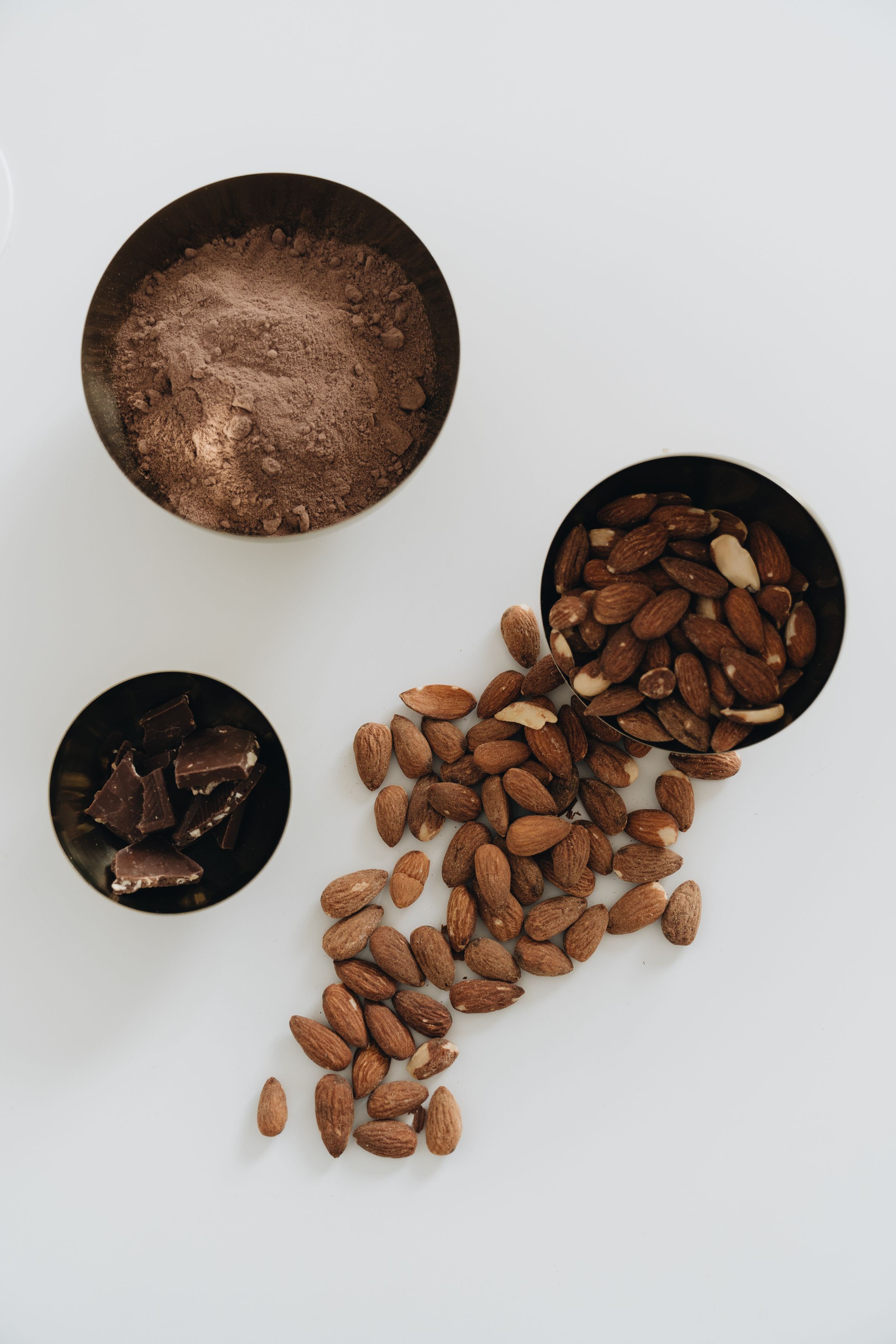 Almonds and pieces of chocolate on a light background.