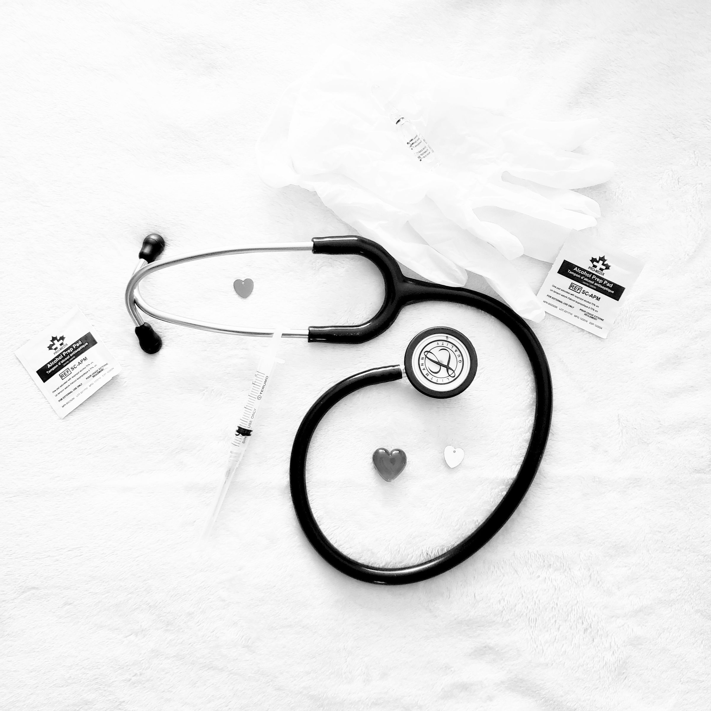 A stethoscope and medical cards on a white surface.