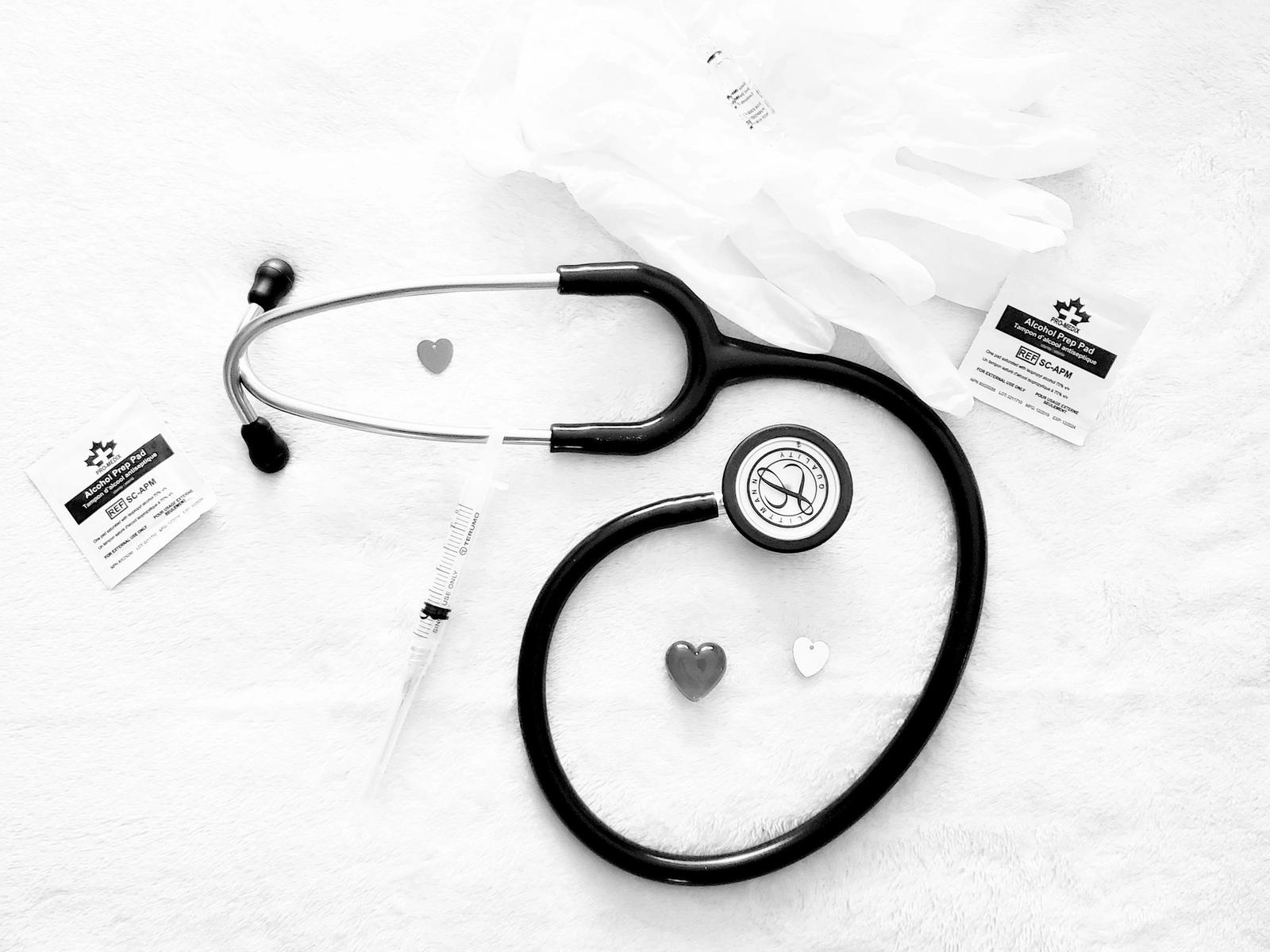 A stethoscope and medical cards on a white surface.
