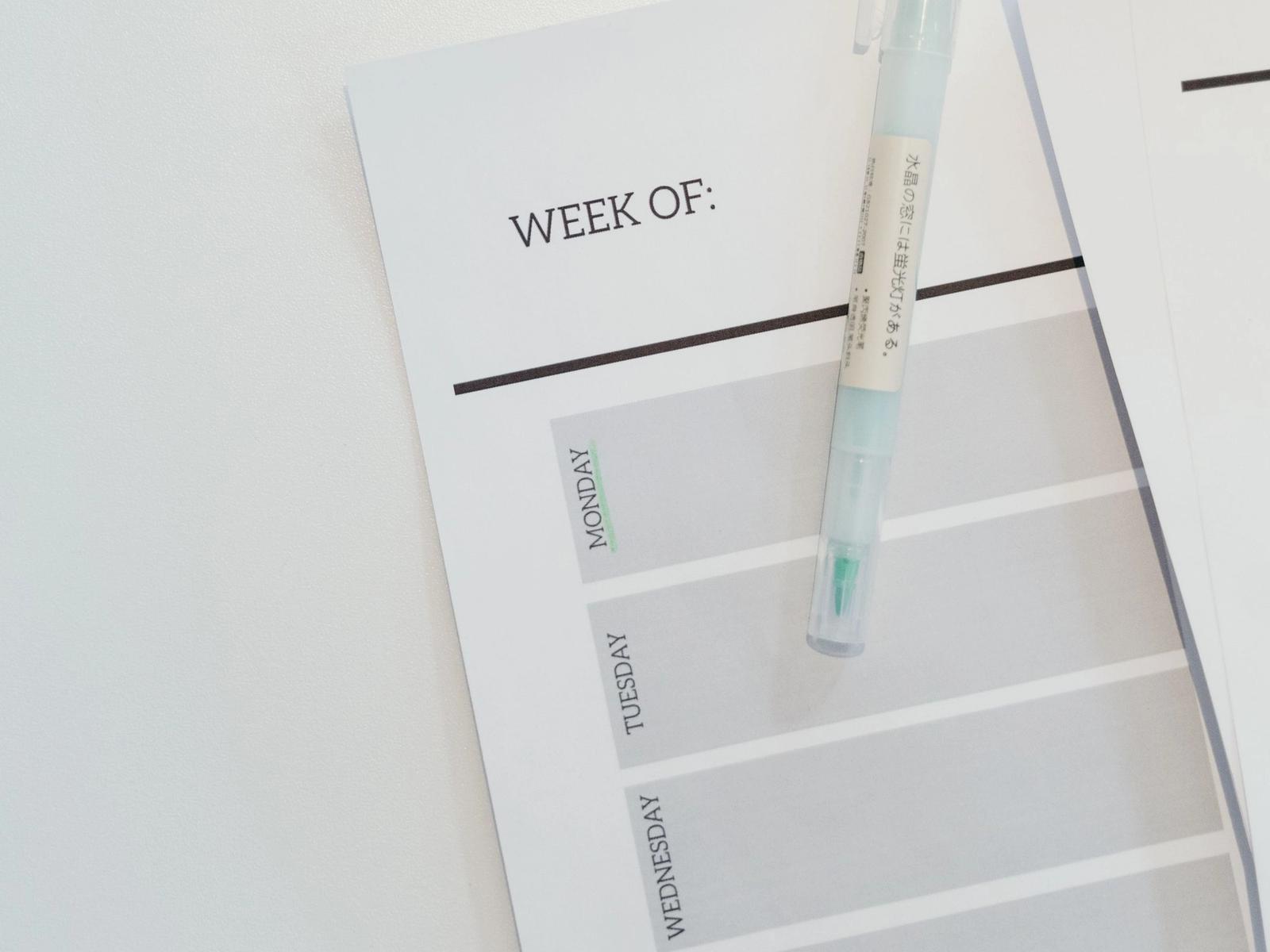 A pen resting on a weekly planner.