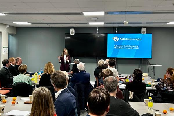 sal med mange mennesker og scene med kvinne