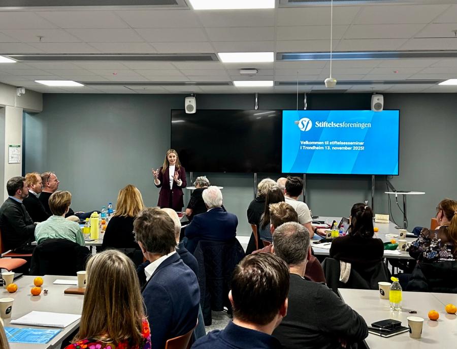 sal med mange mennesker og scene med kvinne