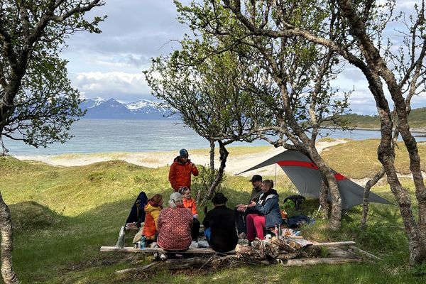 mennesker sitter sammen i naturen