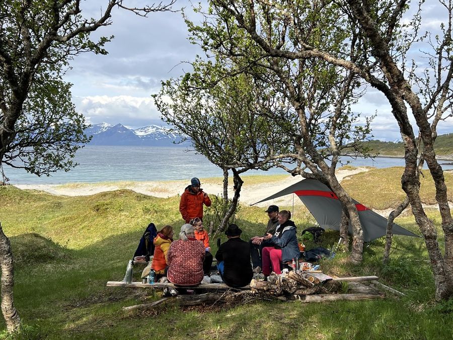 mennesker sitter sammen i naturen