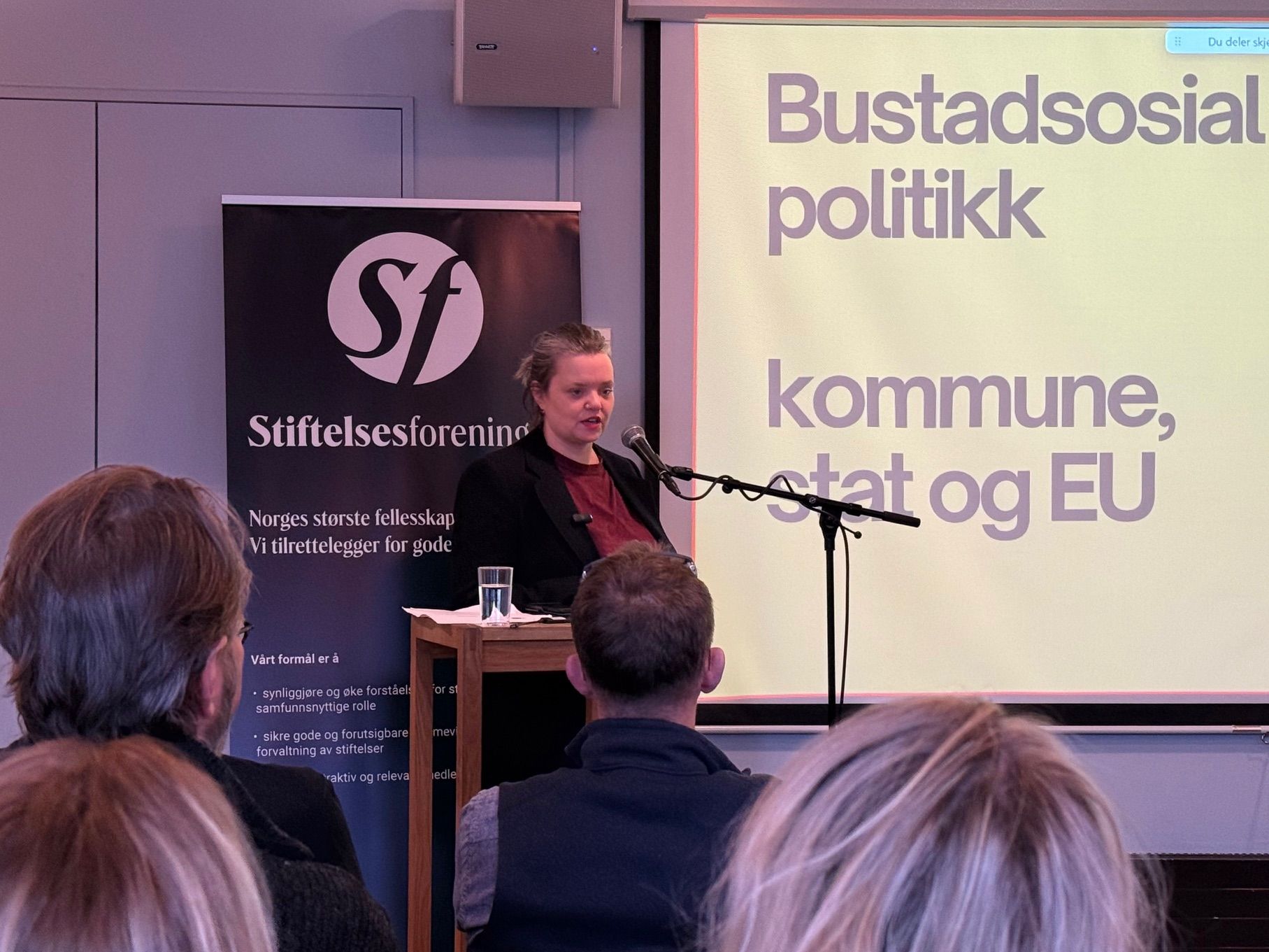 kvinne foran forsamling