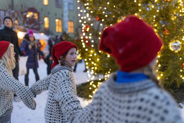 barn med nisselue rundt juletre