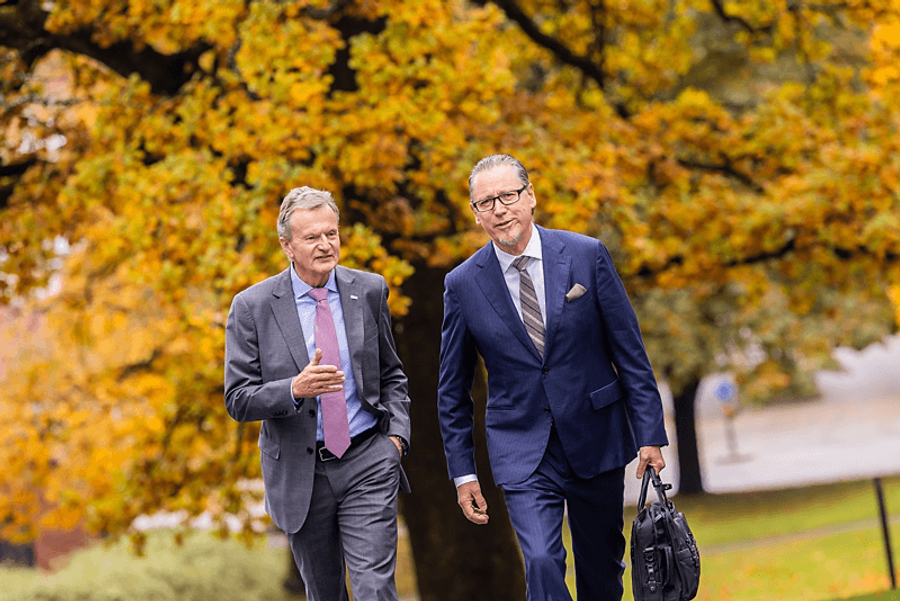 to menn ute foran tre med høstløv