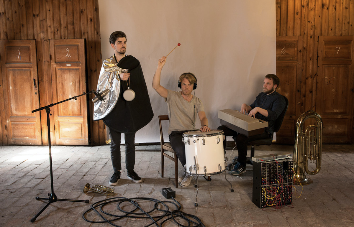 The team from plan8 posing for a photoshoot, holding different instruments