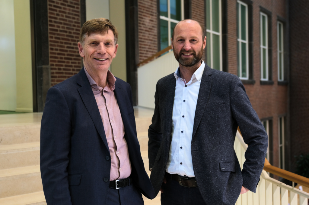 Marcel van Ooijen en Joris van Dam voor een gebouw