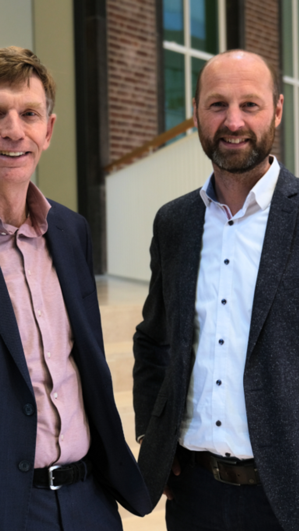Marcel van Ooijen en Joris van Dam voor een gebouw