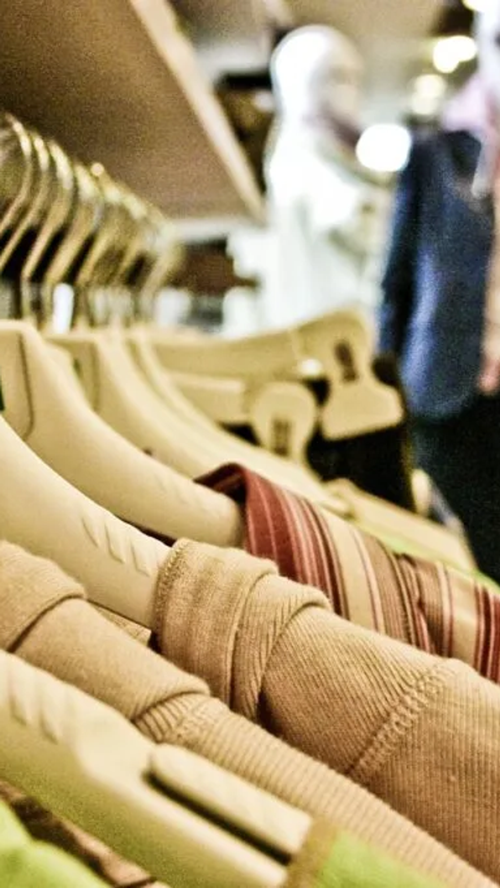 Binnenkant van kledingwinkel. Kledinghangers met kleding en paspoppen