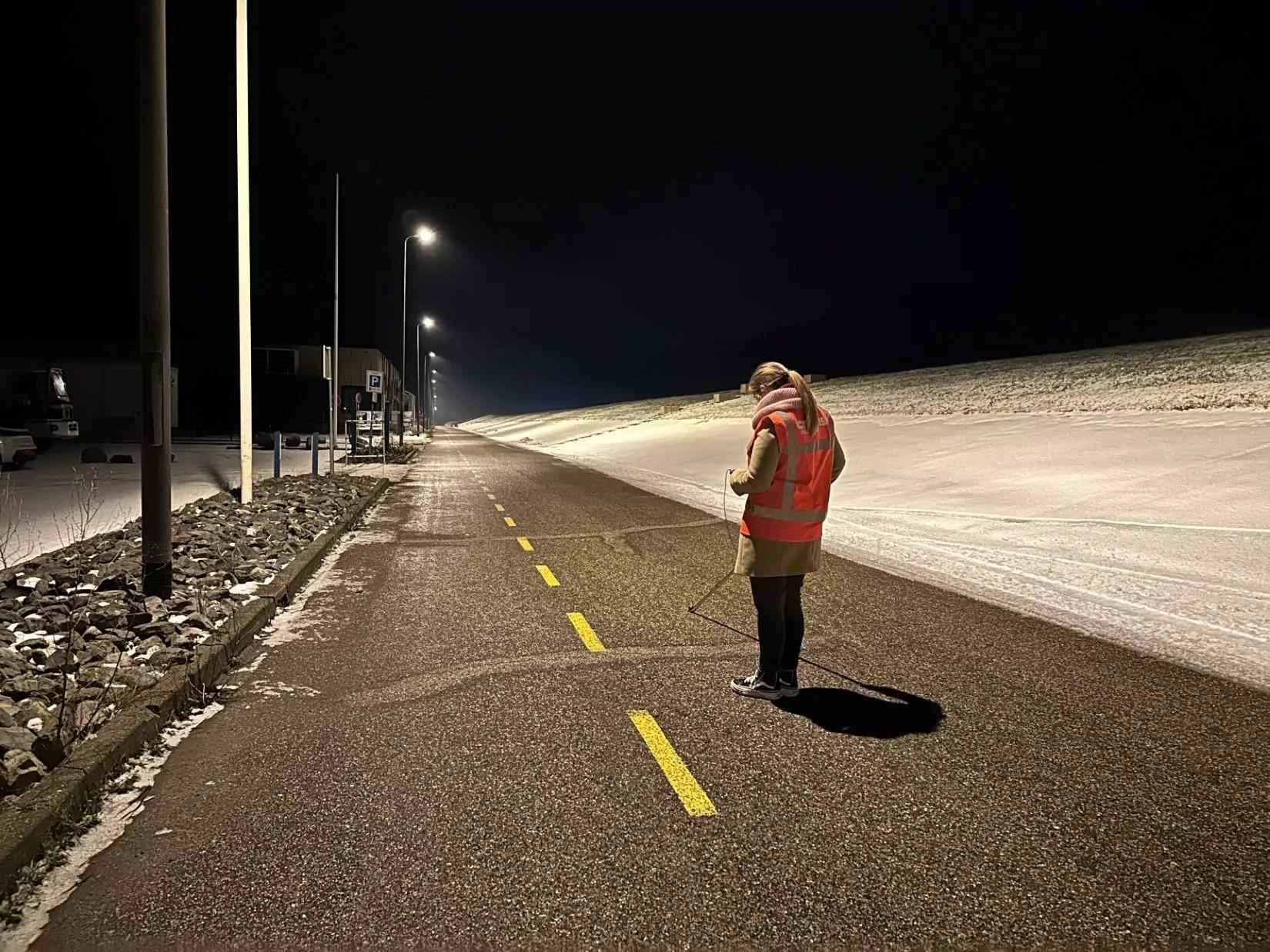 Sophie in het donker in een verlichte straat