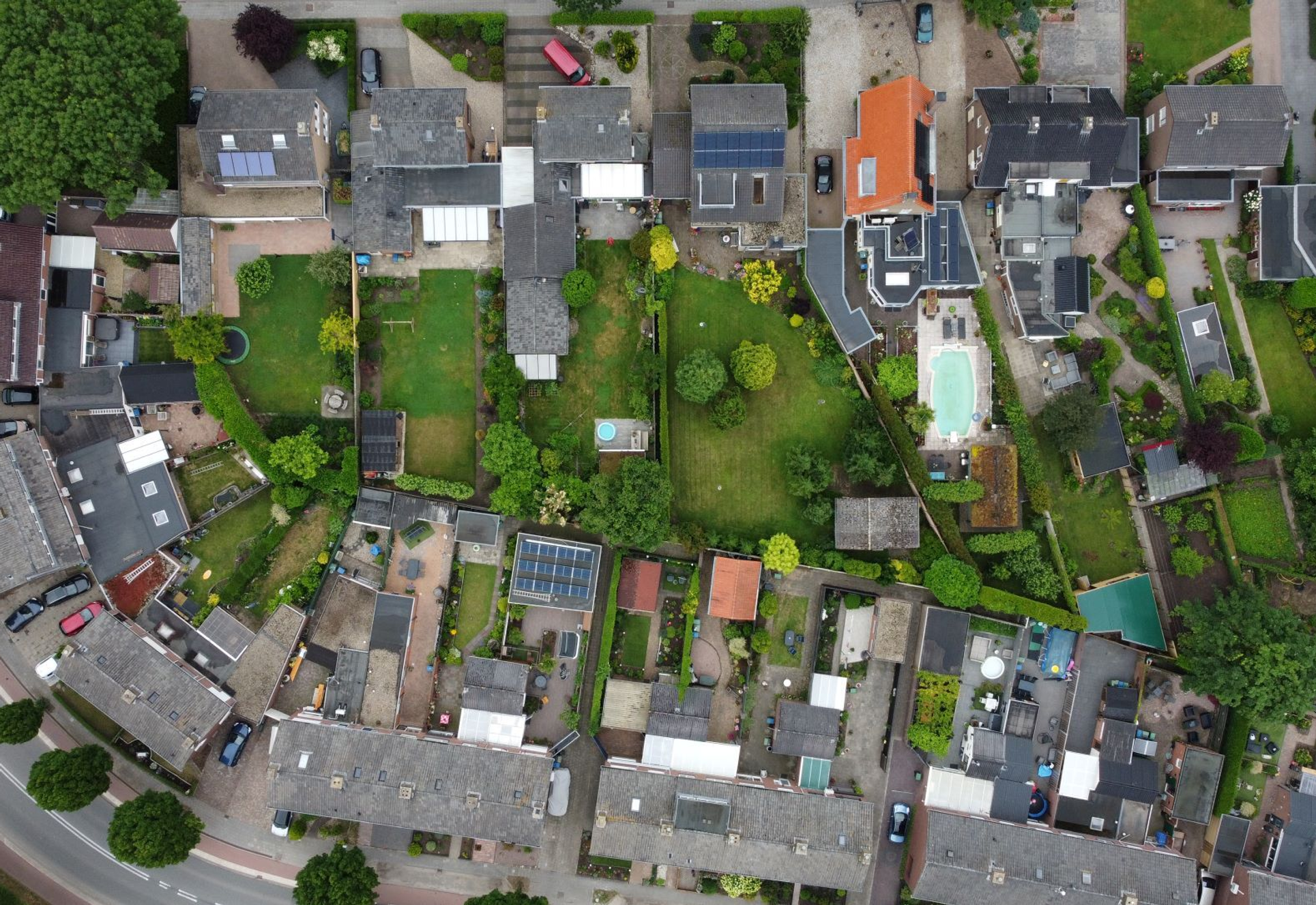 Luchtfoto van een woonwijk met rijtjeshuizen, tuinen en erfafscheidingen – zichtbaar zijn mogelijk onduidelijke grenzen tussen privé- en gemeentegrond (snippergroen).