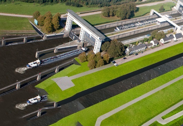 Luchtfoto toont monumentale Prinses Beatrixsluis met witte sluisdeuren, binnenvaartschepen in de sluiskolk en groen landschap rondom het Lekkanaal"