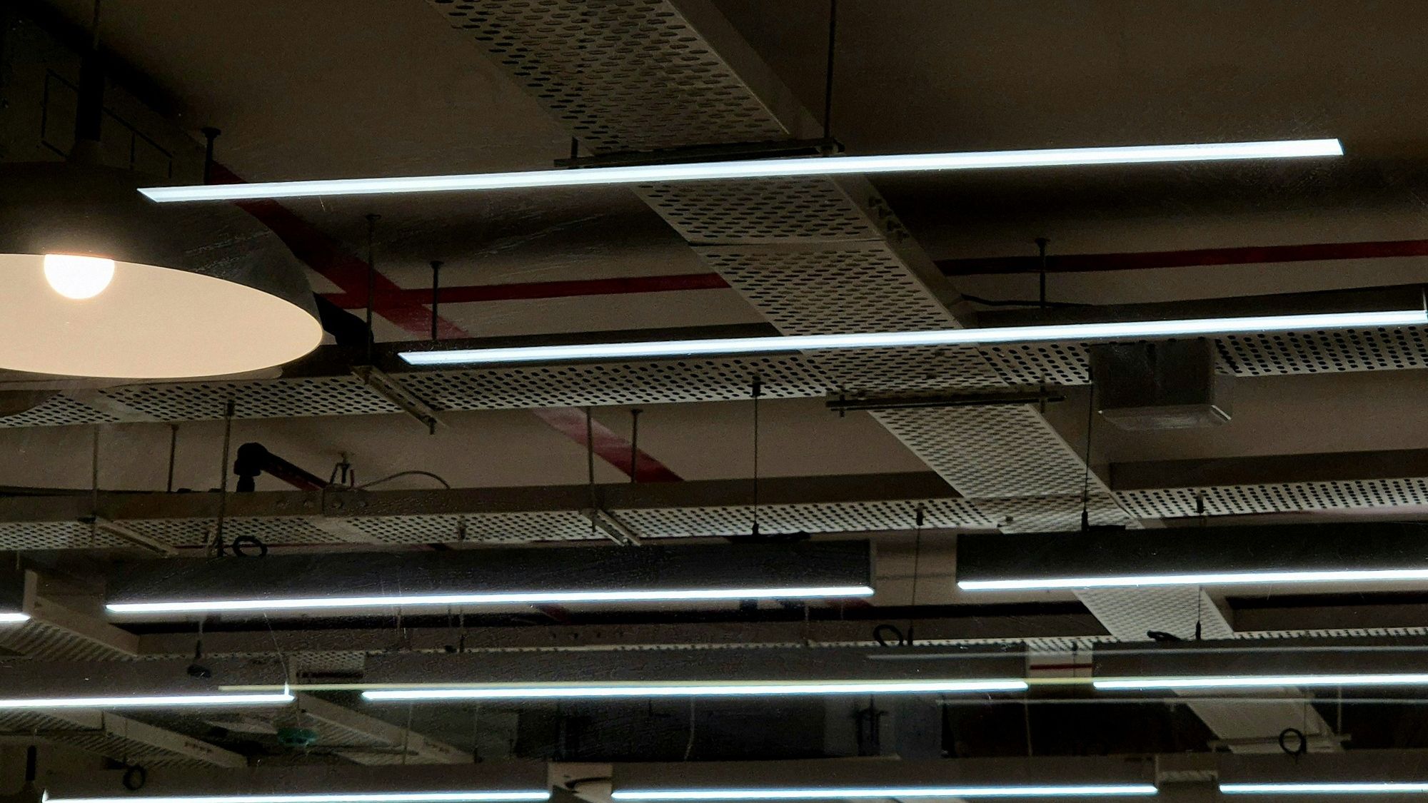 Industrieel plafond met kabelgoten en tl-buizen