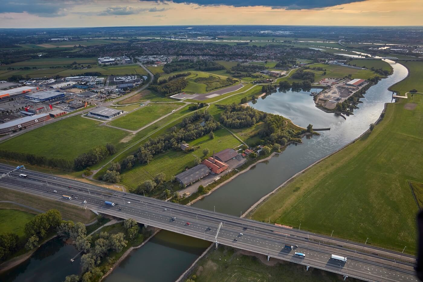 Luchtfoto van rivier, snelweg en groen landschap met industriegebied