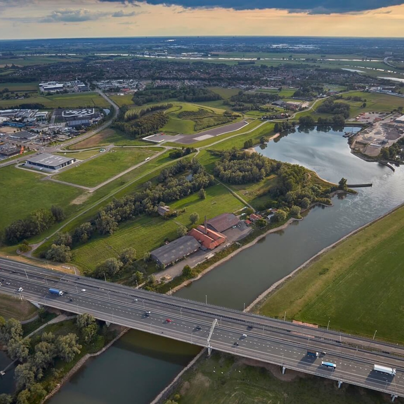 Luchtfoto van rivier, snelweg en groen landschap met industriegebied