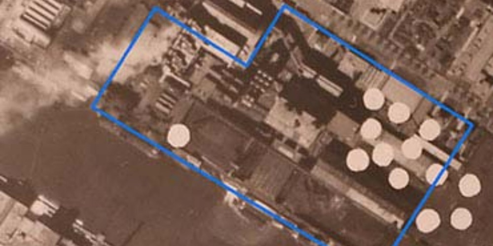 Luchtfoto uit de Tweede Wereldoorlog met blauwe kaders en witte cirkels die mogelijke locaties van bominslagen of Niet Gesprongen Explosieven markeren.