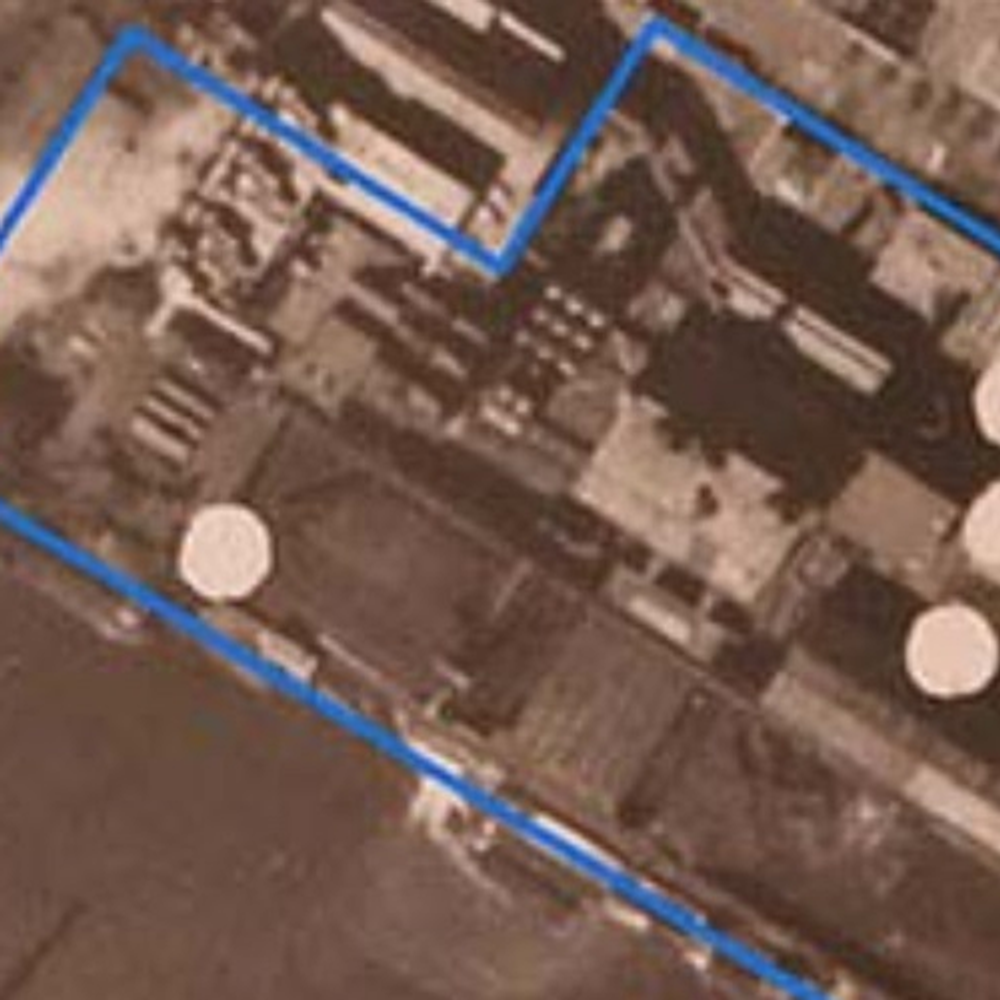 Luchtfoto uit de Tweede Wereldoorlog met blauwe kaders en witte cirkels die mogelijke locaties van bominslagen of Niet Gesprongen Explosieven markeren.