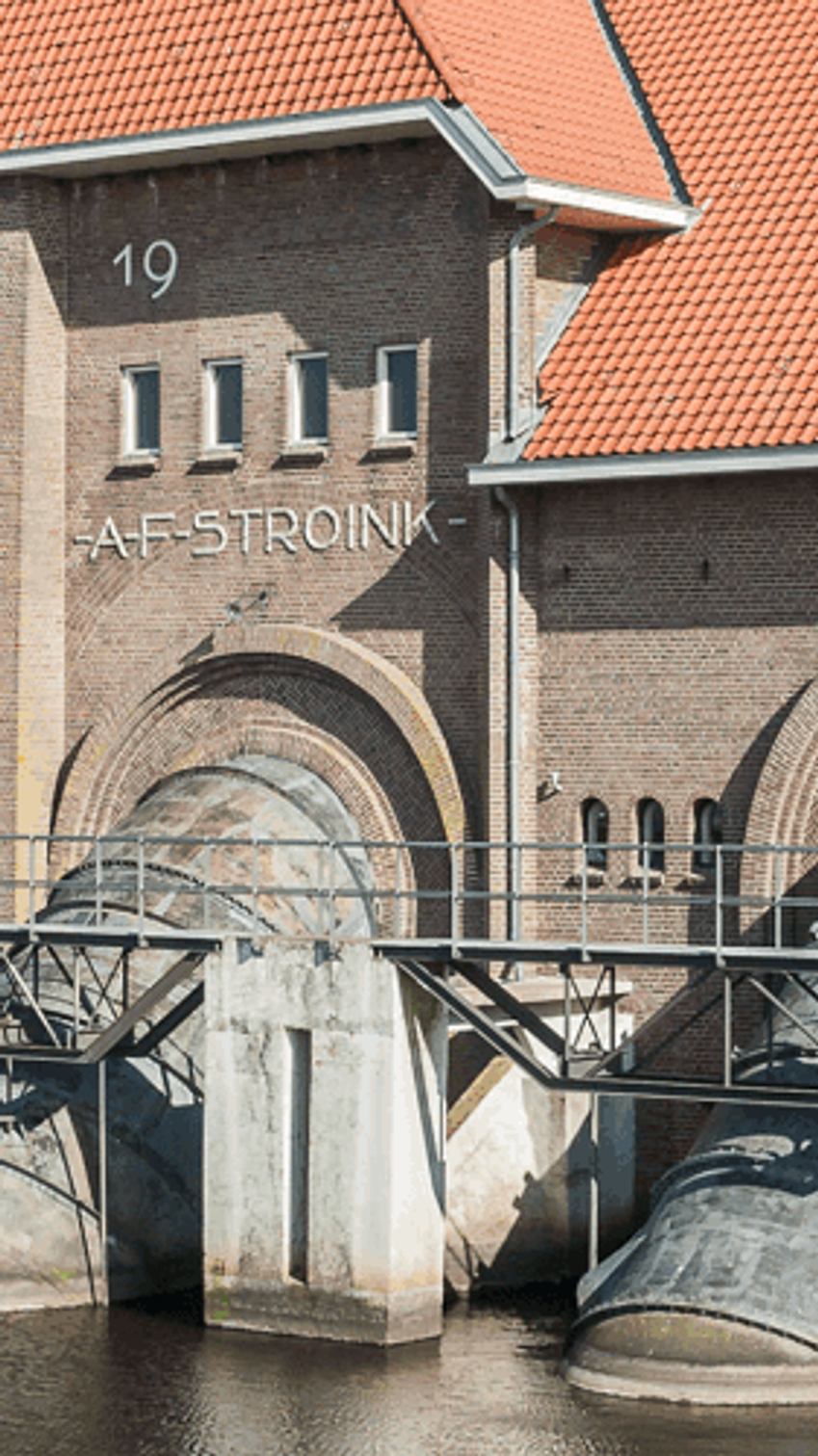 Historisch watergemaal met rode daken en grote ronde waterpoorten