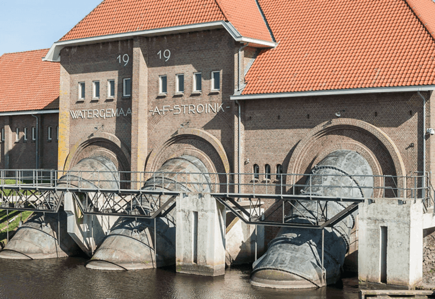Historisch watergemaal met rode daken en grote ronde waterpoorten