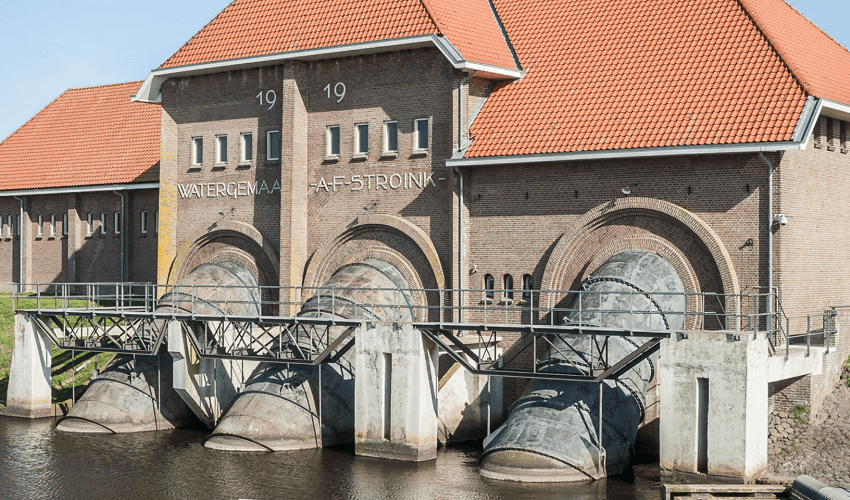 Historisch watergemaal met rode daken en grote ronde waterpoorten