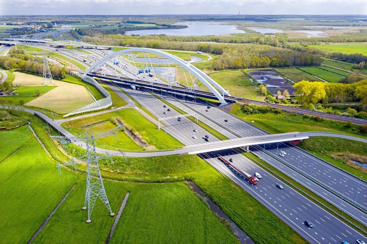Luchtfoto van complex snelwegknooppunt met moderne bruggen door groen landschap