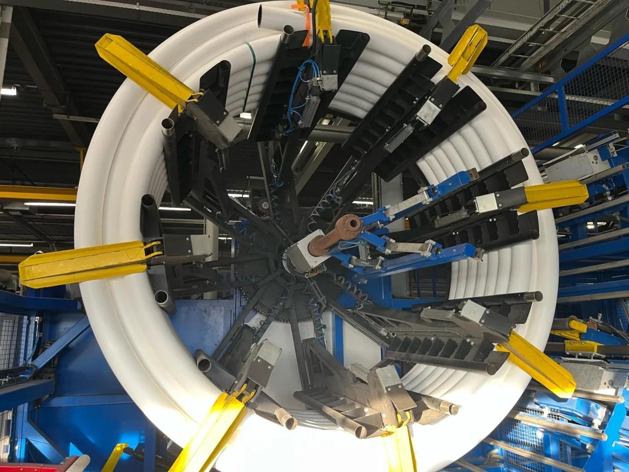 Productielijn voor de fabricage van kunststof leidingen met opgerolde buis en geautomatiseerde wikkelinstallatie.