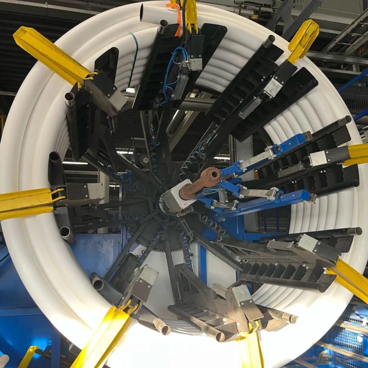 Productielijn voor de fabricage van kunststof leidingen met opgerolde buis en geautomatiseerde wikkelinstallatie.