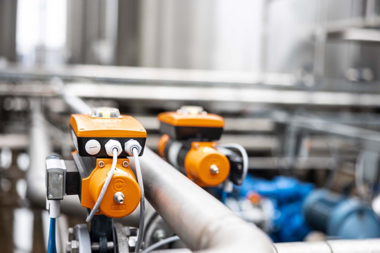 Industriële afsluiters en meetapparatuur op leidingen in een technische installatie.
