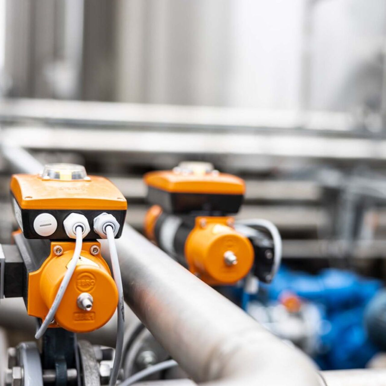 Industriële afsluiters en meetapparatuur op leidingen in een technische installatie.