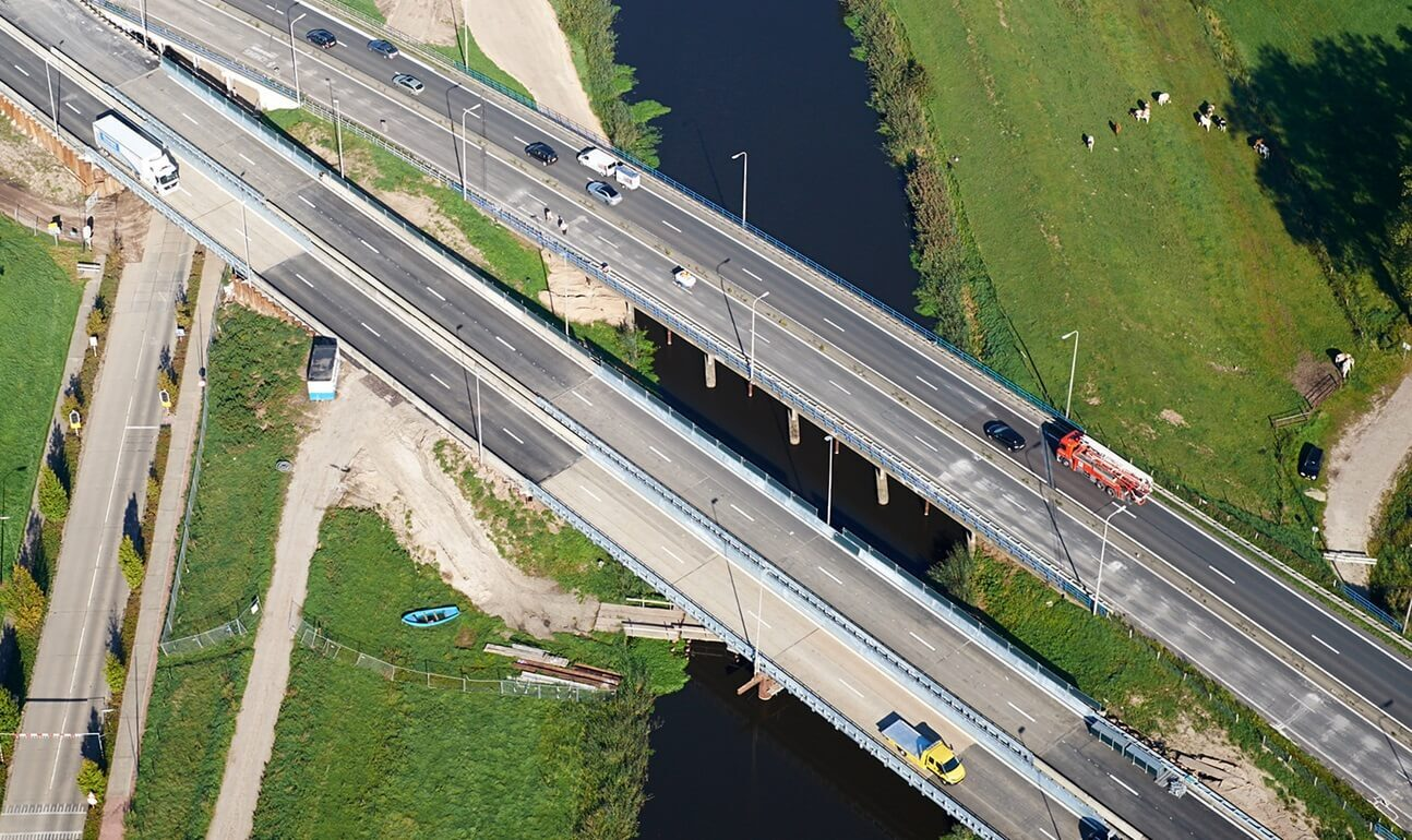 Luchtfoto van snelwegbrug over water met meerdere rijstroken en verkeer
