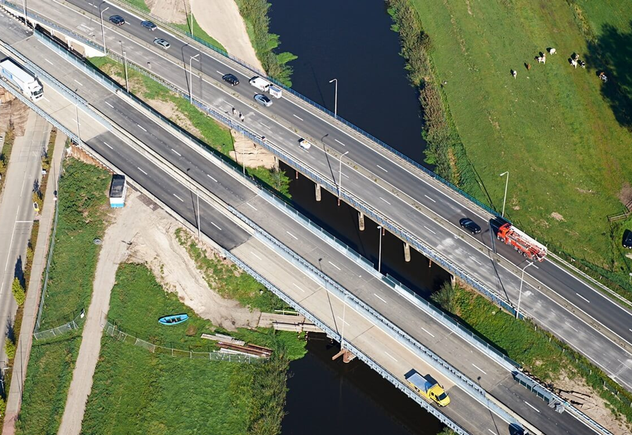 Luchtfoto van snelwegbrug over water met meerdere rijstroken en verkeer