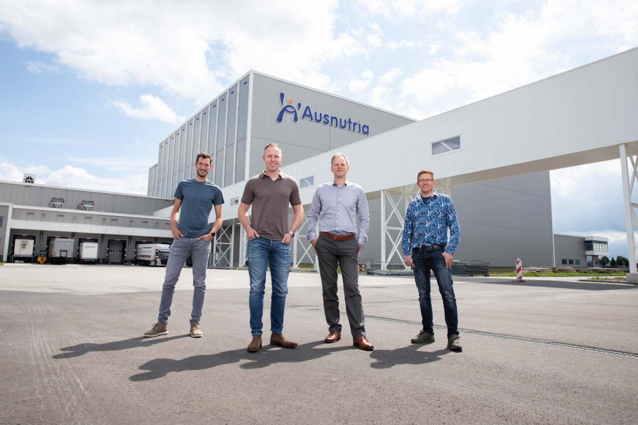Vier mannen voor een groot gebouw