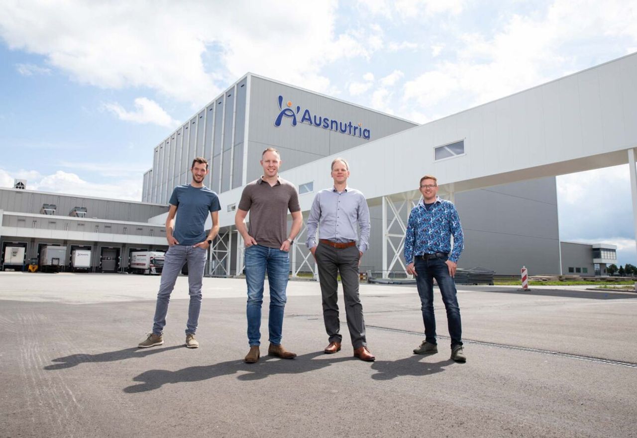 Vier mannen voor een groot gebouw