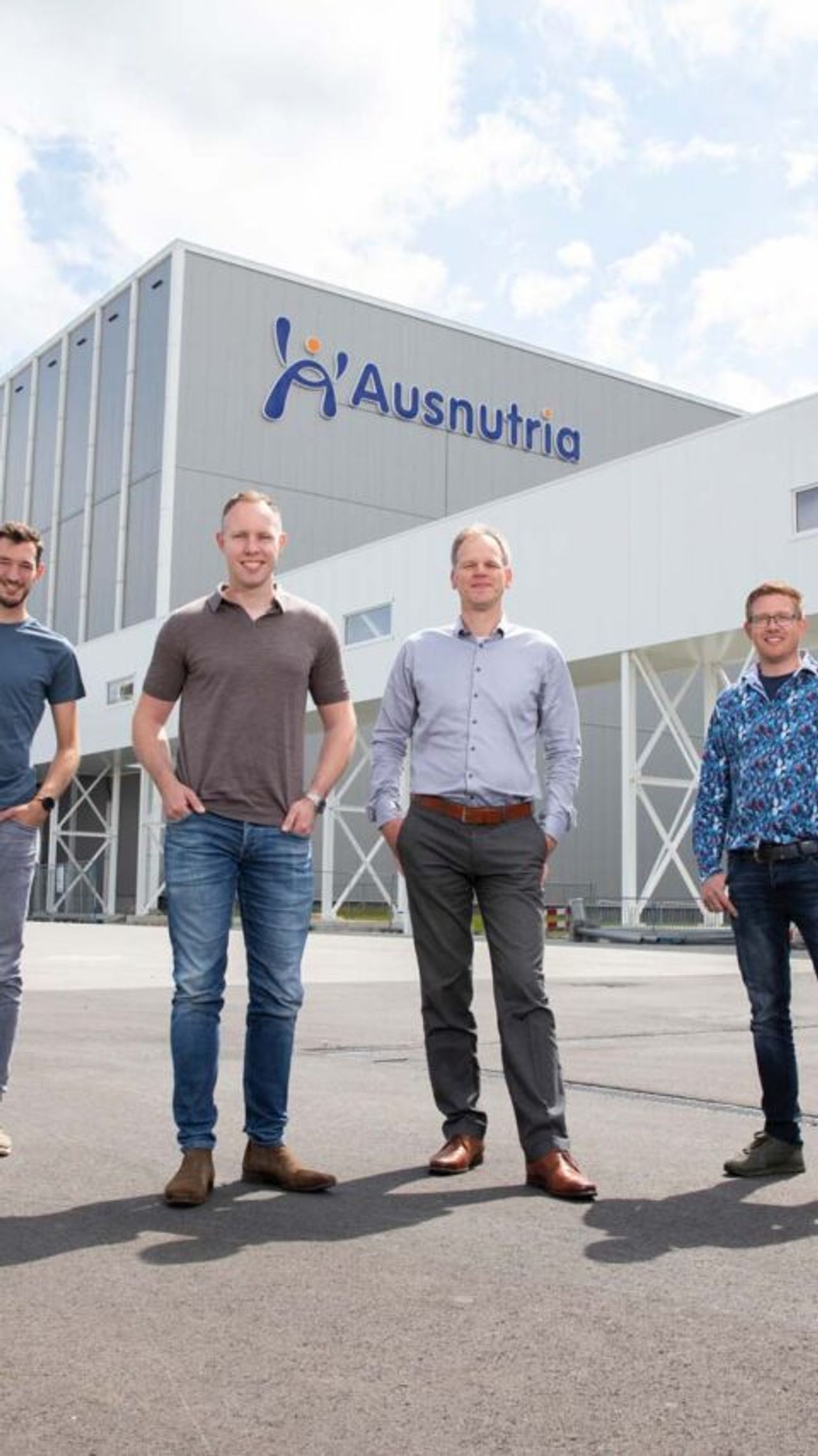 Vier mannen voor een groot gebouw