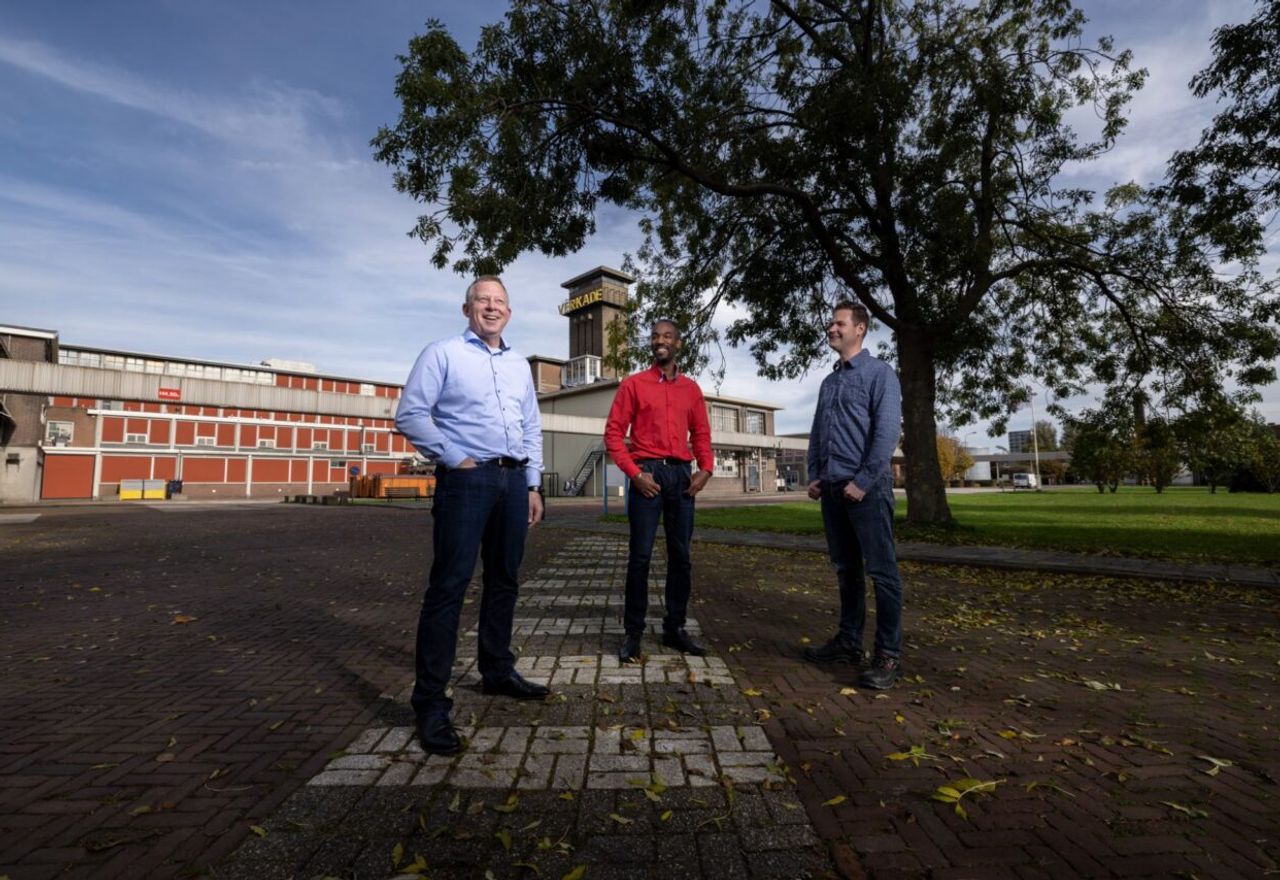 3 mannen voor een gebouw