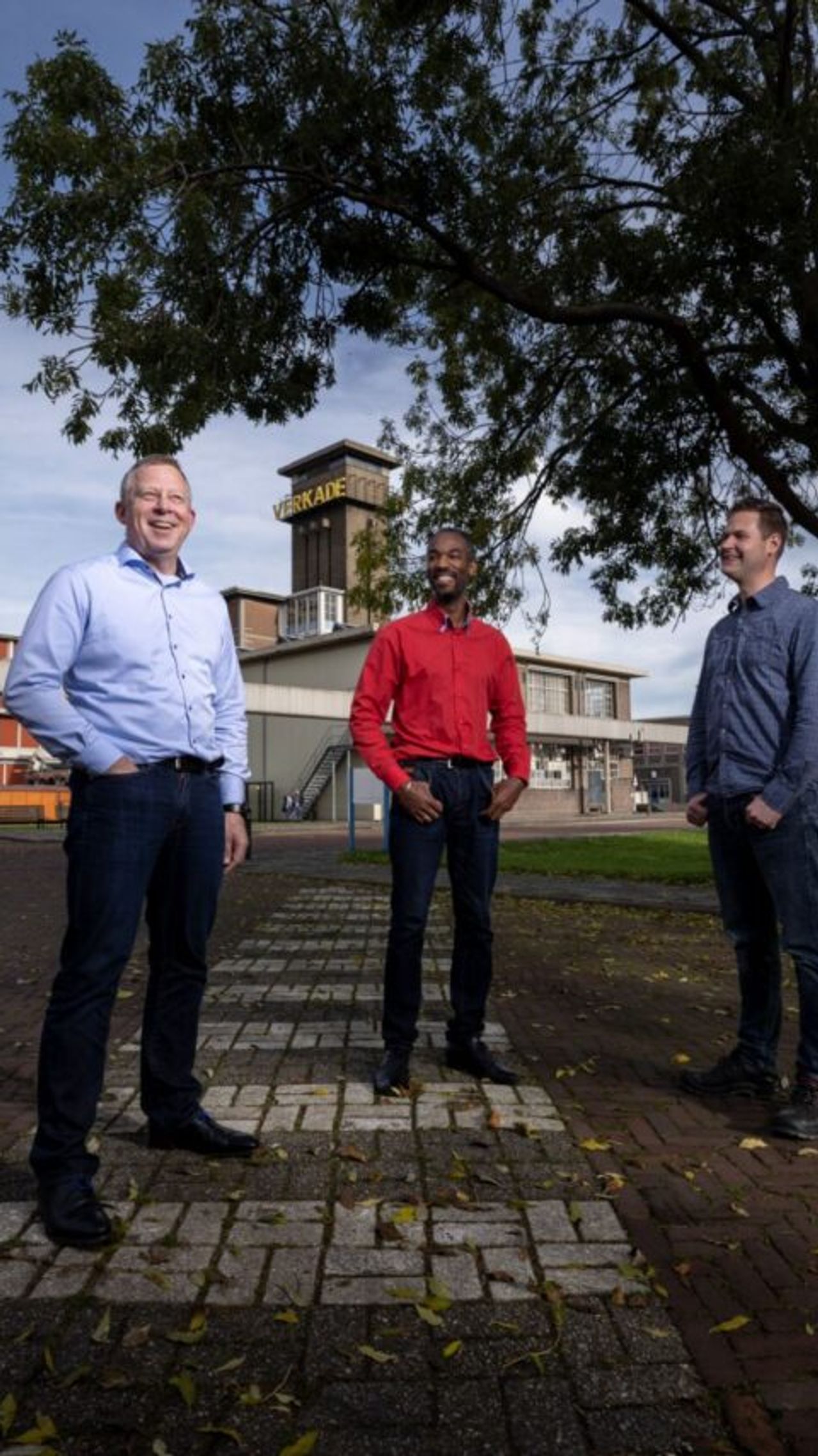 3 mannen voor een gebouw