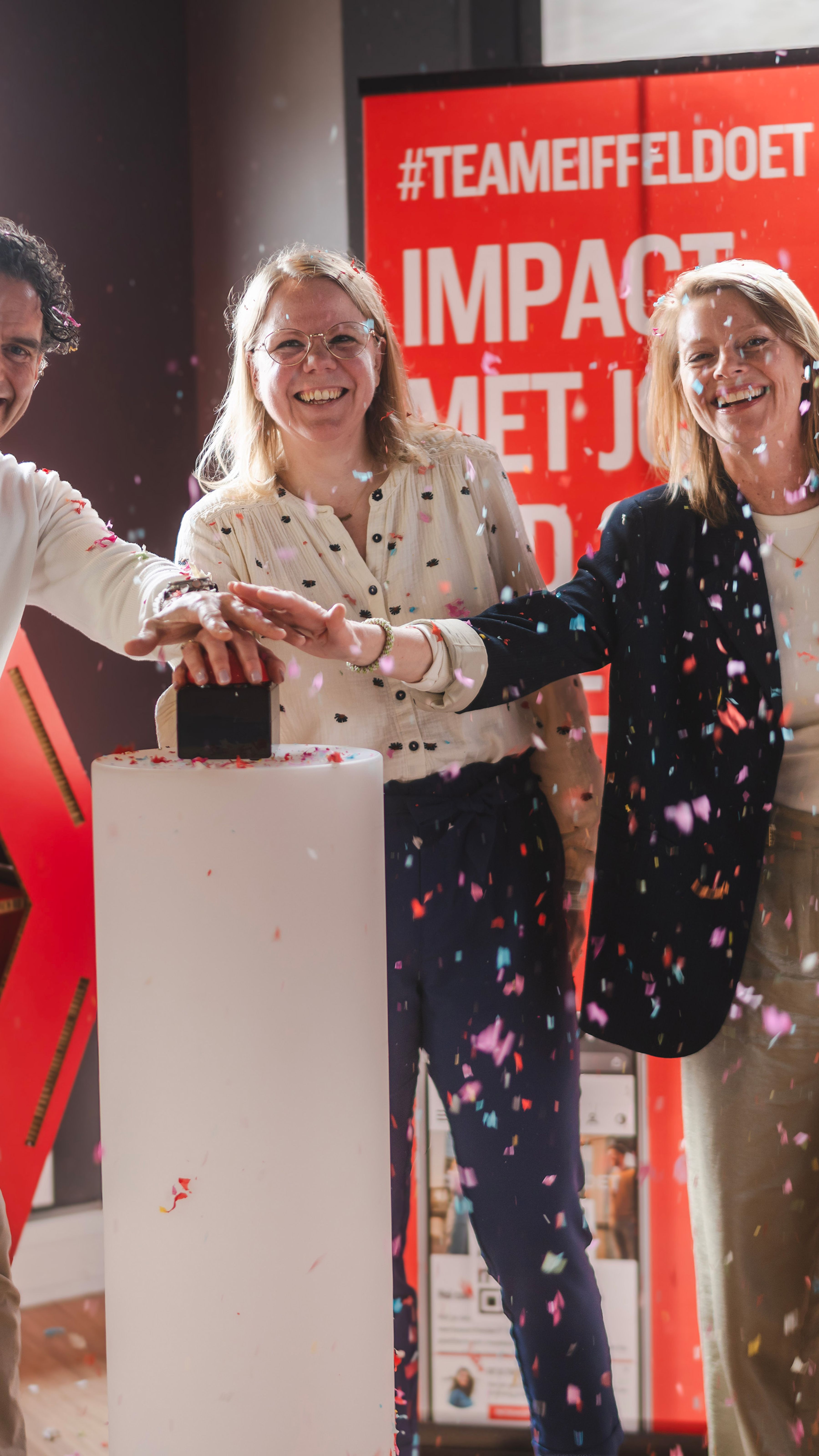 Drie personen drukken op een livegang button met confetti in de lucht