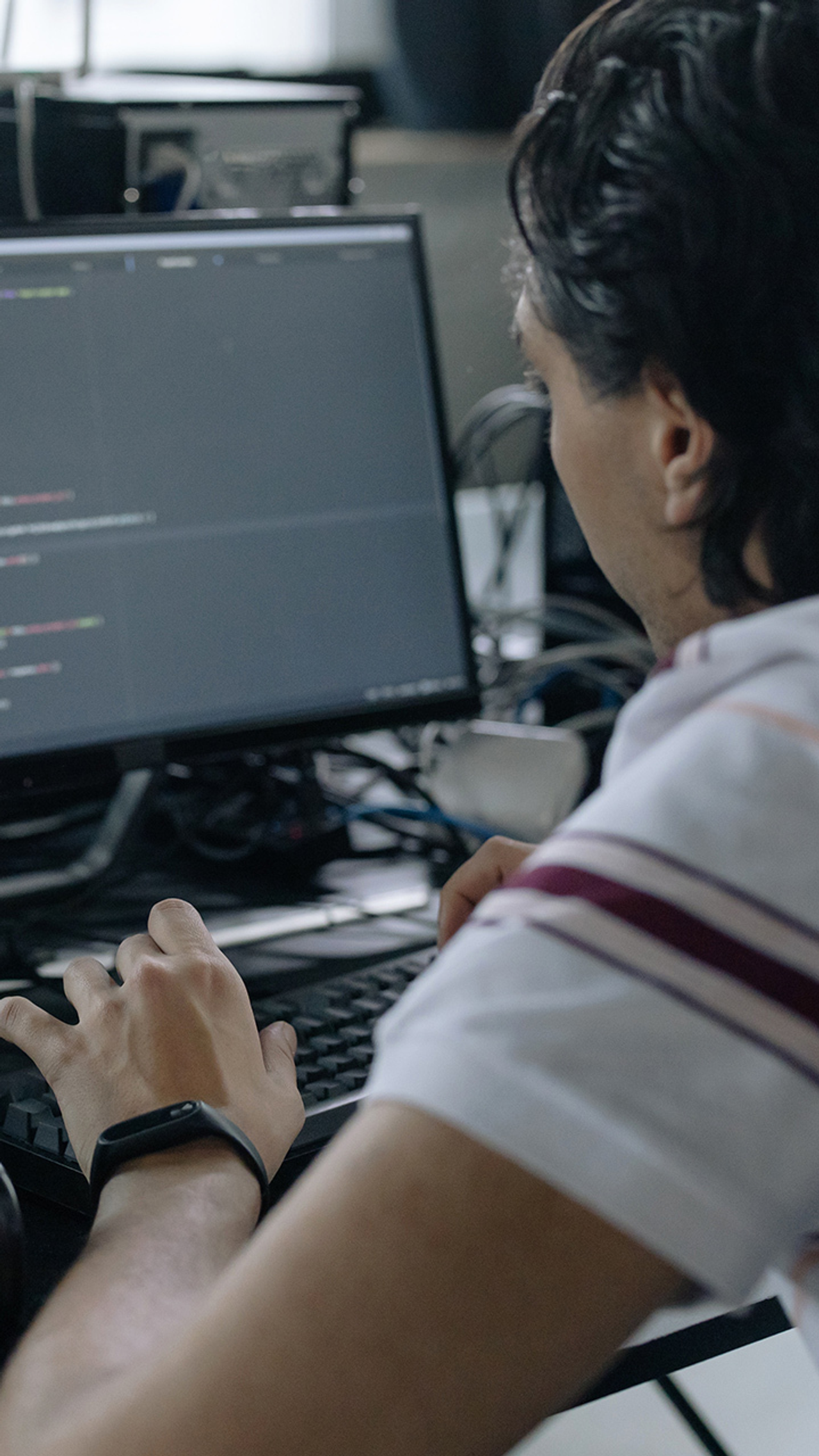 Man werkt aan programmeercode op computerscherm in een kantooromgeving