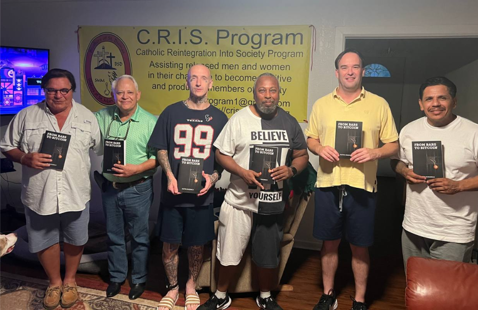 Six adults pose holding identical black books.