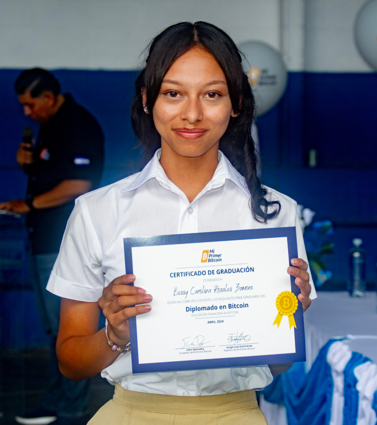 A person poses with their graduation certificate.