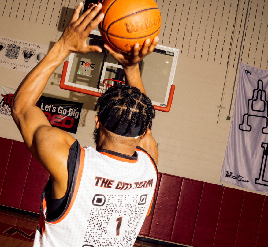 A person in a basketball jersey shoots a basket.