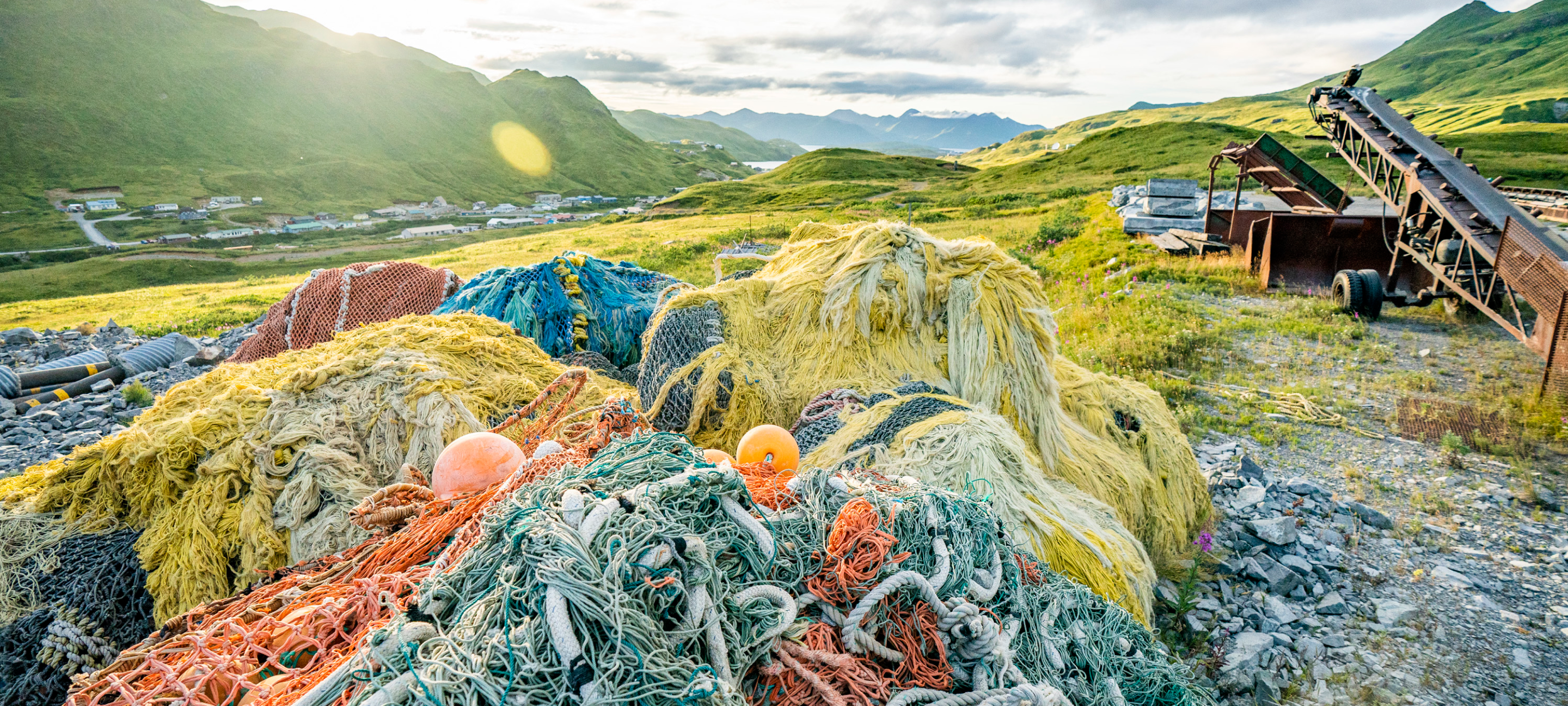 A pile of fishing nets on a grassy hill.